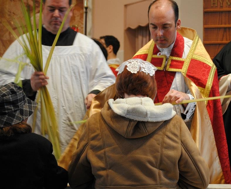 Father presents the blessed palm to the faithful, who kiss the palm and then Father's hand